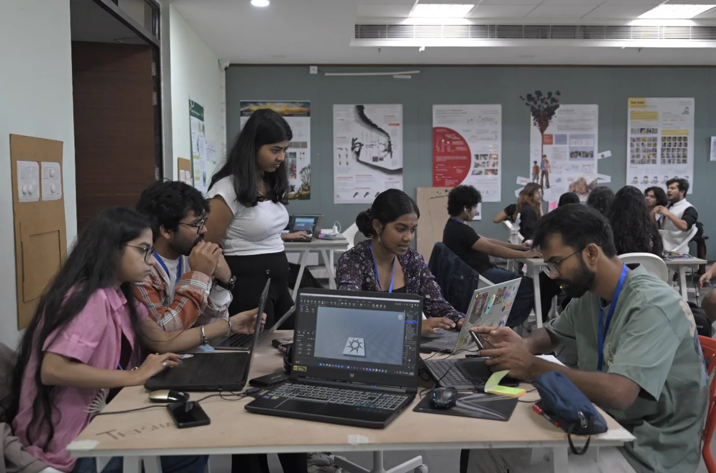 Student creators collaborating around laptops during a game jam.